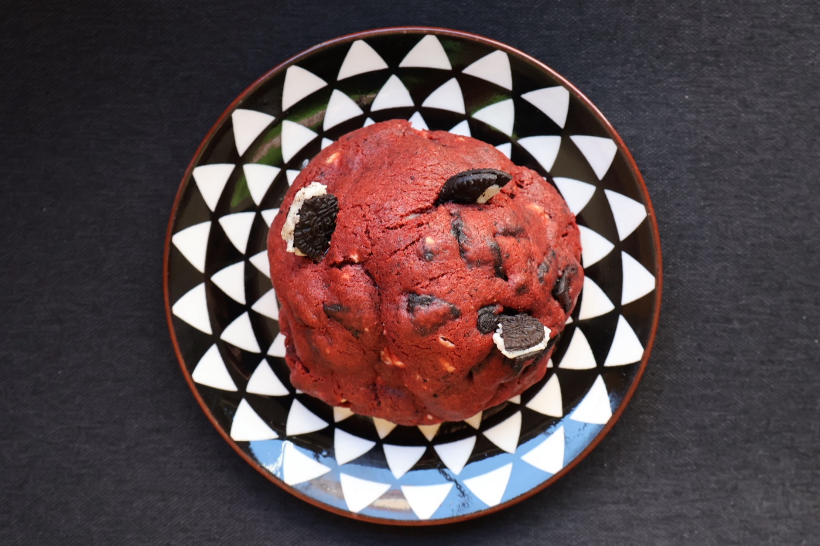 Cookie red velvet cu bucăți de biscuit cu cacao, pe o farfurie cu model